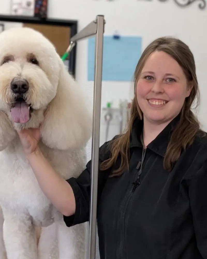 Micaela with a big white Poodle she just groomed.