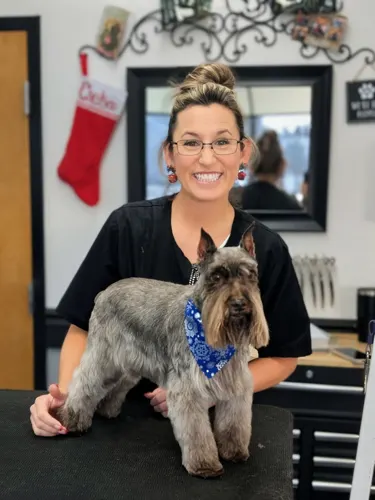 Chelsea, owner of Zuzu's Pet Spa, with a freshly groomed dog.